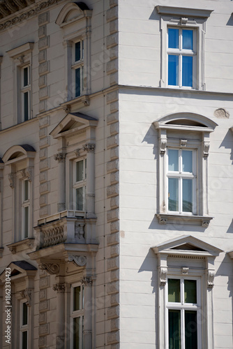 Wallpaper Mural Historic building facade with tall windows, decorative frames and balcony, strong daylight casting sharp shadows, highlighting classical urban architecture, texture, symmetry, and timeless city charac Torontodigital.ca