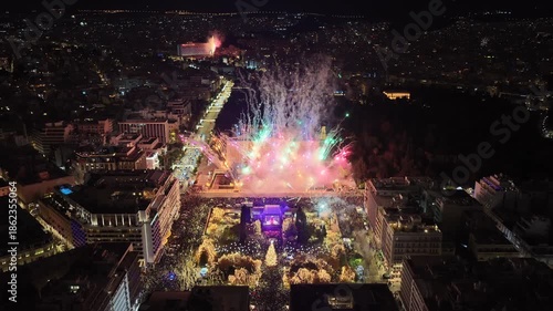 Aerial drone cinematic video of illuminated festive Syntagma square featuring firework show and Christmas tree during New Year's Eve, Athens centre, Attica, Greece