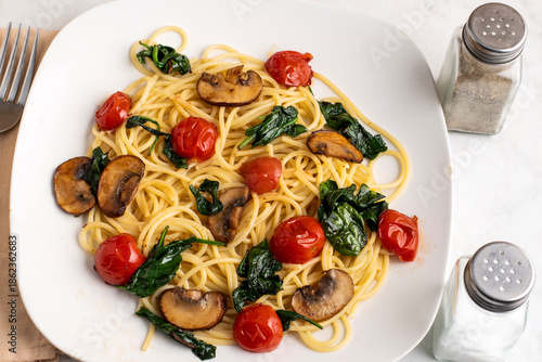spaghetti top with mushrooms, tomatoes and spinch
