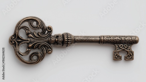 Antique ornate bronze key on white background.