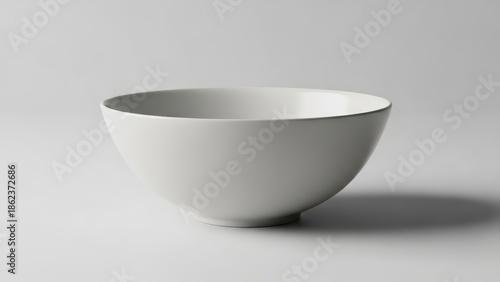 Modern white ceramic bowl on gray background with shadow