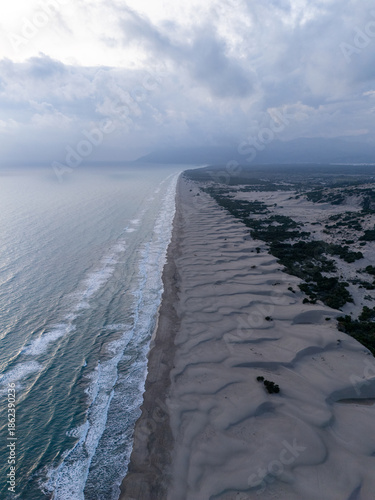Aerial view of Patara Beach with its golden sand dunes stretch along crystal-clear turquoise water, one of the longest and most unspoiled beaches in Antalya, Turkey.