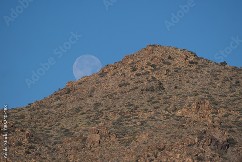mountain landscape with blue sky and full moon