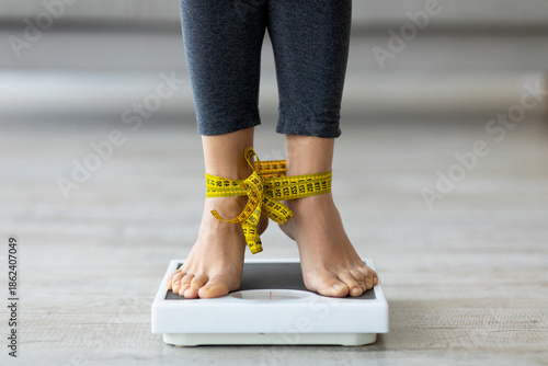 Foto Unrecognizable Indian woman standing on scales with tied feet, checking her weight
