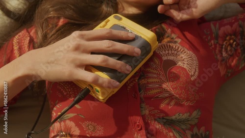 Trendy dreamcore woman listening to portable cassette player on bed stretches to get up