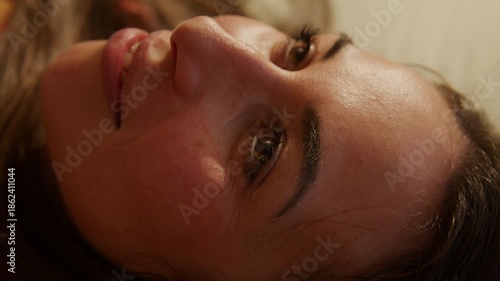 Young Woman Dreamcore - Listing to music laying in bed smiling - close up
