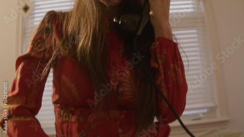 Retro dreamcore woman sits on bed and dials on old rotarty phone - move from hands to face