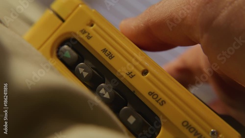 Hand tapping along on portable cassette player while listening to music - extreme close up on cassette player