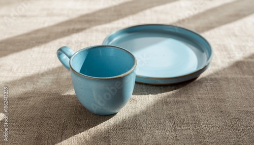 Patina blue ceramic cup and plate set with soft shadows, minimal tableware background