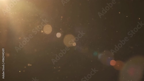 Aerial view of glowing lights in a dark environment with lens flares and bokeh effects