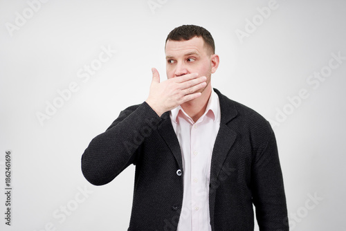 Fényképezés portrait of man with hand over his mouth looking aside, stunned and speechless c