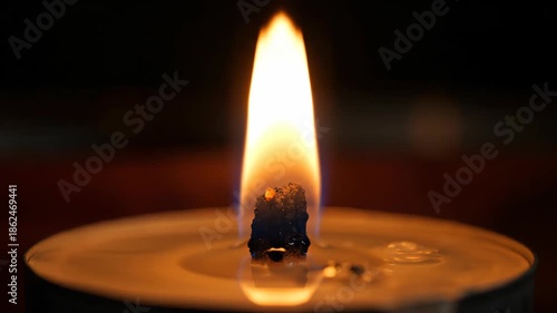 A Single Candle Flame Burning Brightly in the Dark.