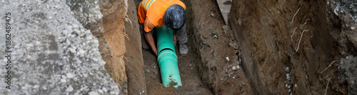 Tableau sur toile Construction worker in deep trench protected by Trench Box, coffin, while instal