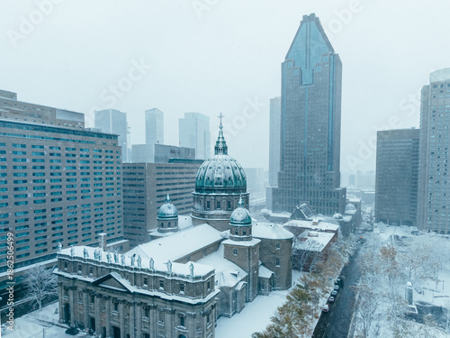 Snowy aerial view of Montreal downtown with Mary Queen of the World Cathedral during snowfall and storm. g.