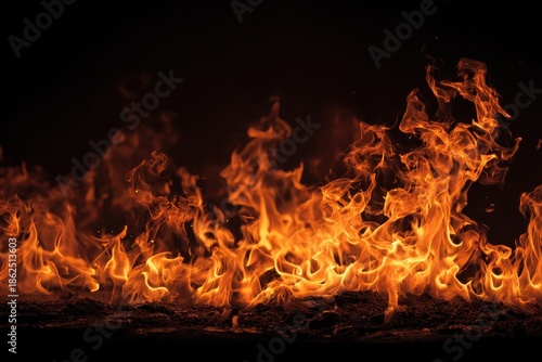 Roaring flames blaze against a stark black background in this vibrant image. Use for concepts like passion, danger, energy, or natural disasters.