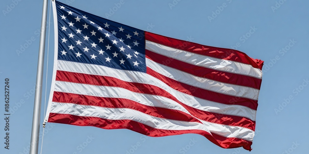 Fototapeta premium American flag waving proudly against a clear blue sky on a sunny day