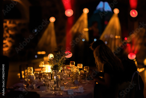 Canvas-taulu Candlelit luxury dinner table at an elegant evening event with wine glasses, floral centerpiece, and dramatic ambient lighting, creating a romantic, cinematic atmosphere