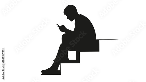 Silhouette of a young man intensely focused while sitting alone on steps engaging with his small handheld mobile communication device
