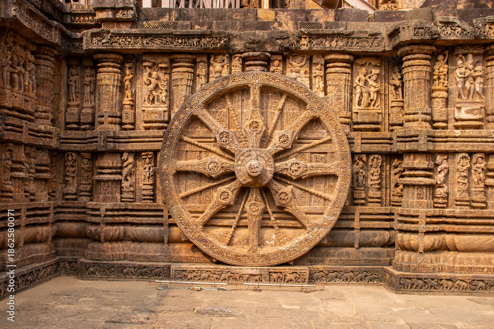 Obraz premium Majestic Konark Sun Temple wheel, intricately carved sandstone, symbolizes celestial chariot, precise spokes and deities, embodying timeless craftsmanship, astronomy, devotion, heritage of Odisha Indi