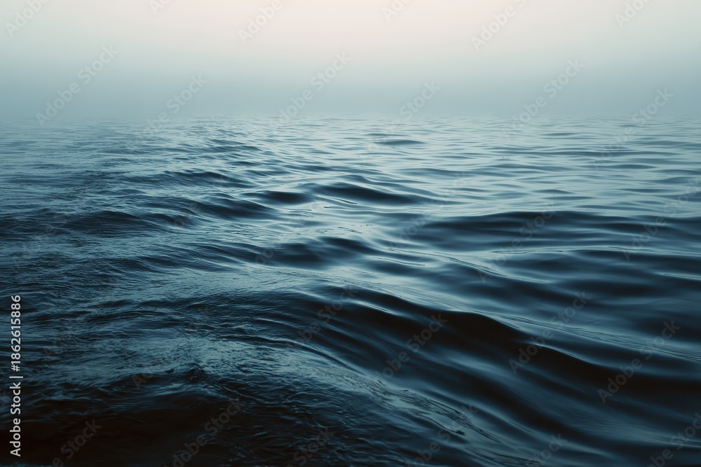 Fototapeta premium Morning fog blankets serene sea ripples, creating a tranquil atmosphere over calm waters at dawn