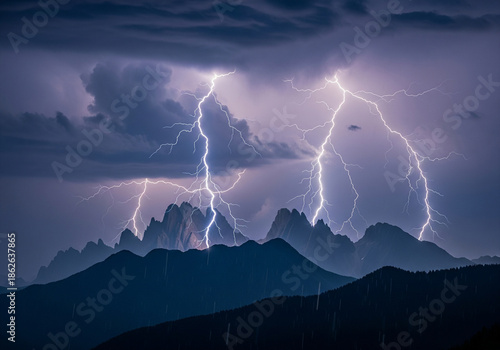 Powerful lightning bolts dramatically illuminate rugged mountain peaks during an intense electrical storm, revealing nature's raw energy and breathtaking awe