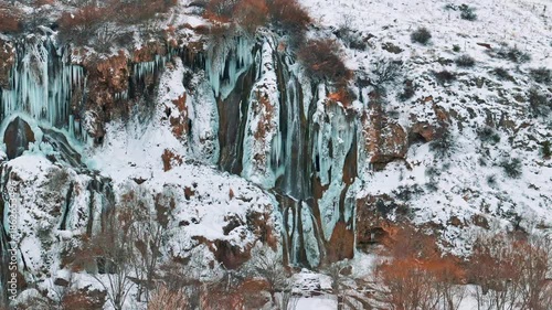 Aerial view of a frozen waterfall in winter with a drone