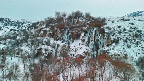 Aerial view of a frozen waterfall in winter with a drone