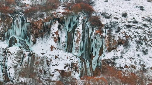 Aerial view of a frozen waterfall in winter with a drone
