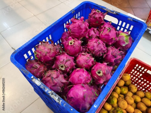 Vibrant Dragon Fruits in a Blue Crate at the Market