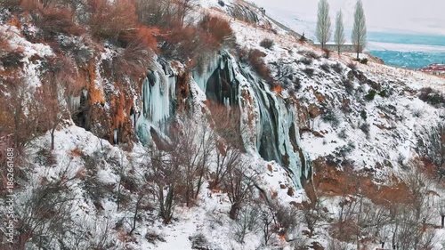 Aerial view of a frozen waterfall in winter with a drone