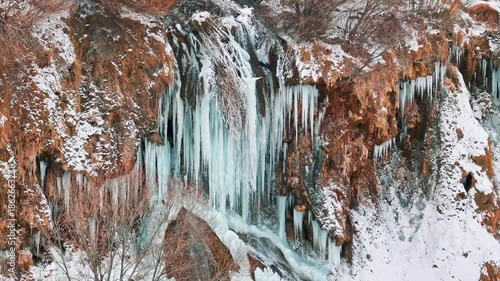 Aerial view of a frozen waterfall in winter with a drone