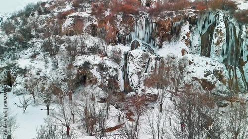Aerial view of a frozen waterfall in winter with a drone
