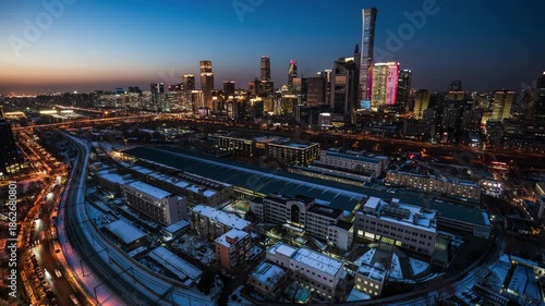Urban nightscape of Guomao CBD architectural complex in Beijing China at dusk, featuring the metropolitan railway hub