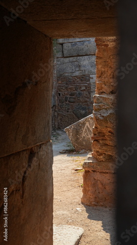 Ancient ruins seen through a stone doorway at an archaeological site. This historic landmark features antique masonry, weathered walls, and the remnants of a great civilization.