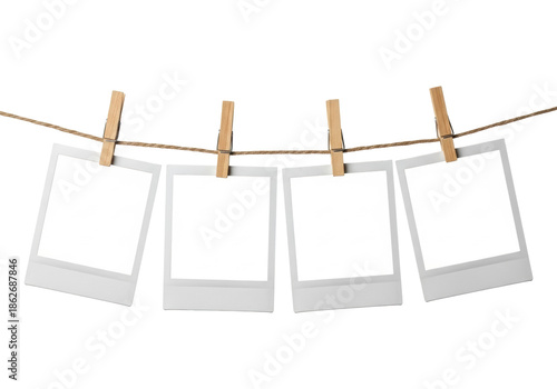 Wallpaper Mural Four blank Polaroid-style instant photo prints, white borders, wood clothespins, rustic twine, isolated on transparent with diffused studio lighting, clean professional product display concept. Torontodigital.ca