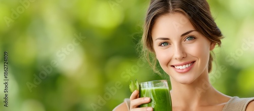 Smiling young woman holding a glass of green detox diet smoothie