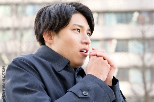 Fotografija 冬のオフィス街で寒そうな日本人男性
