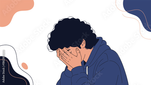 A young man with curly hair covering his face with both hands, feeling sad, desperate, or stressed about a problem.