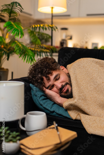Arabian man at home feels drained after heavy work rests head on pillow closes eyes wants sleep deep. Egyptian guy on sofa breathes slow releases stress falls asleep calm body relaxed after long day.