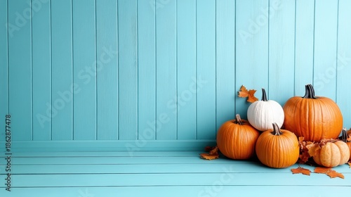 A captivating arrangement of pumpkins in various colors, set against a vibrant blue wooden backdrop, evoking autumn vibes and seasonal charm.