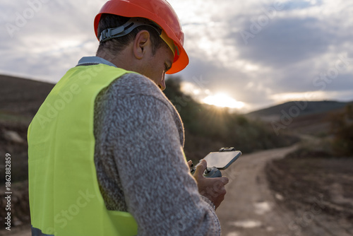 Engineer operating drone for inspecting renewable energy infrastructure in rural landscape