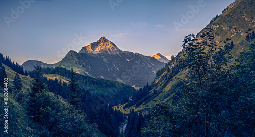 Last sunlight illuminates the summit of Mount Biberkopf (2599 m) on the German-Austrian border, a rugged peak of the Allgäu Alps, captured in dramatic alpine evening light.