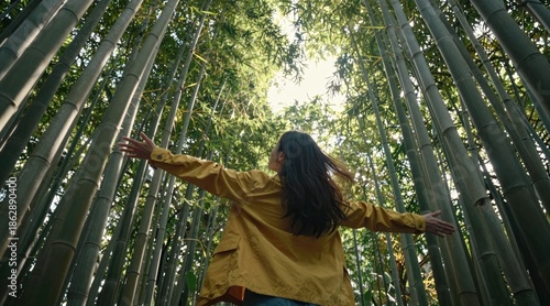 Sustainable eco-friendly travel tourist Person standing in a bamboo forest, arms outstretched, embracing nature's tranquility.