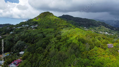 Coastal Village and Residential Area Against Steep Forested Hills and Extensive Shallow Reefs