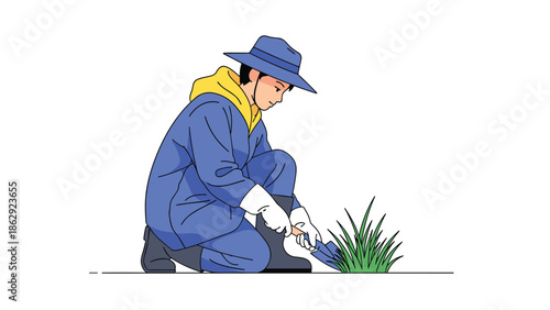 Farmer wearing a blue work suit and hat kneeling to tend to green plants in a field with a small shovel during spring.