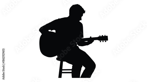 Silhouette of a musician playing an acoustic guitar while seated