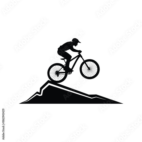 Silhouette of a mountain biker riding up a steep hill