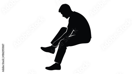 Silhouette of a man sitting with his head in his hands