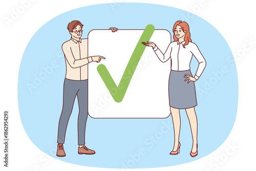 Business partners have completed project show check mark proving completion of assigned tasks. Man and woman office employees striving together to achieve commercial goals and complete project
