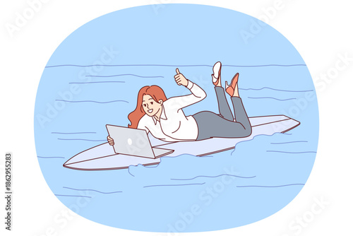 Woman freelancer rides surfboard on sea and works with laptop, showing thumbs up. Busy girl freelancer in casual clothes jobs during vacation due to lack of time management skills.
